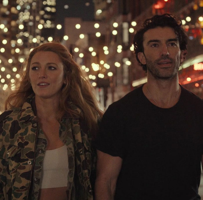 Man and woman walking at night with city lights in the background, related to Ryan Reynolds legal battle texts case news.