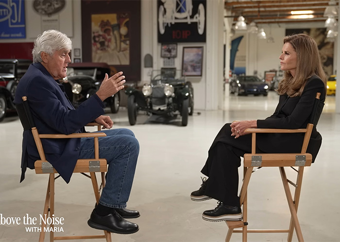 Jay Leno seated in a garage interview setting, appearing thoughtful while discussing his wife&rsquo;s struggle with dementia.