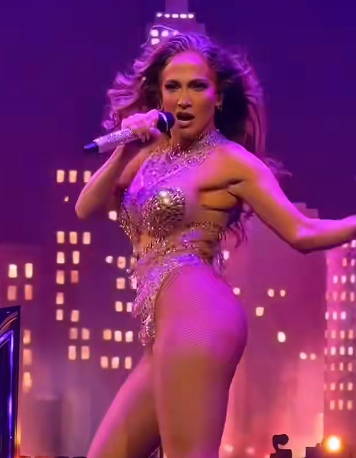 Jennifer Lopez performing on stage in a sparkly outfit, going viral for responding to dress her age comments.