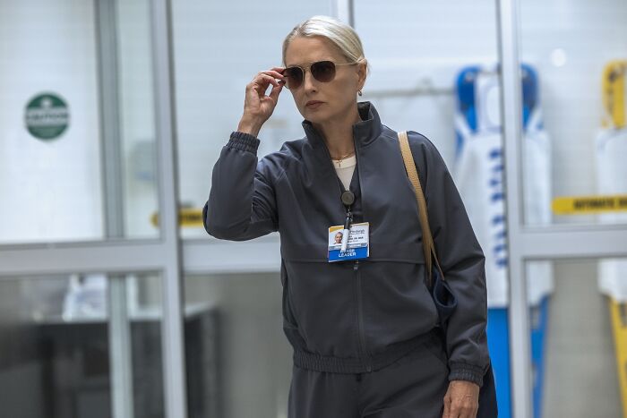 Katherine LaNasa portraying Nurse Dana, inspired by her cancer diagnosis, wearing dark medical scrubs and sunglasses. - 3