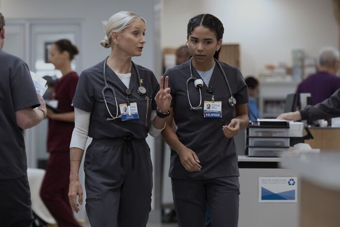 Katherine LaNasa as Nurse Dana in a hospital setting, discussing patient care with a colleague in scrubs. - 4