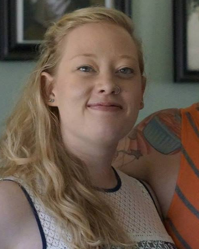 Young woman with long blonde hair and nose ring smiling indoors, linked to Kyle Rittenhouse and ICE slaying Minneapolis discussion.