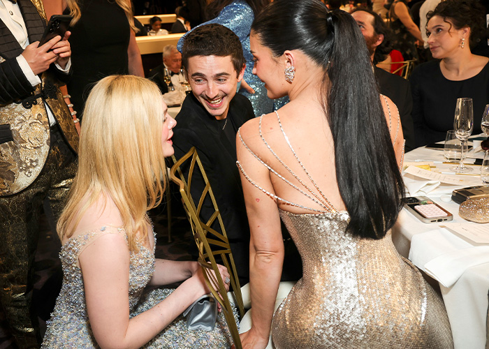 Kylie Jenner at Golden Globes in sparkly dress, sparking debate over her unusual seat arrangement at the event.