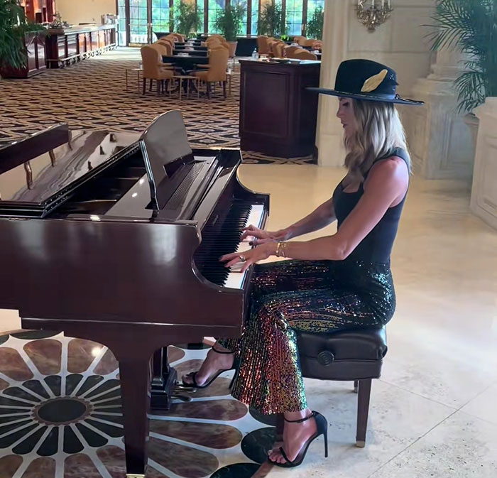 Lara Trump playing piano in a hat and sequined pants, spotlight on dance moves from new music video exposure.