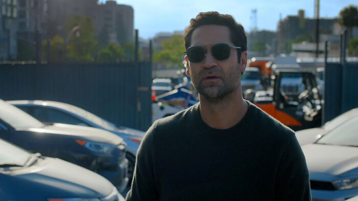 Man wearing sunglasses standing outdoors near parked cars, highlighting 5 most anticipated TV releases of February 2026. - 1