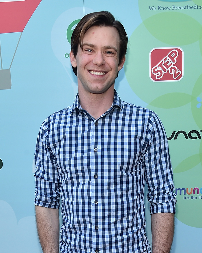 Young man in blue checkered shirt smiling at an event, related to Little Rascals star and Catholic extremist news. Young man in blue checkered shirt smiling at an event, related to Little Rascals star and Catholic extremist news.