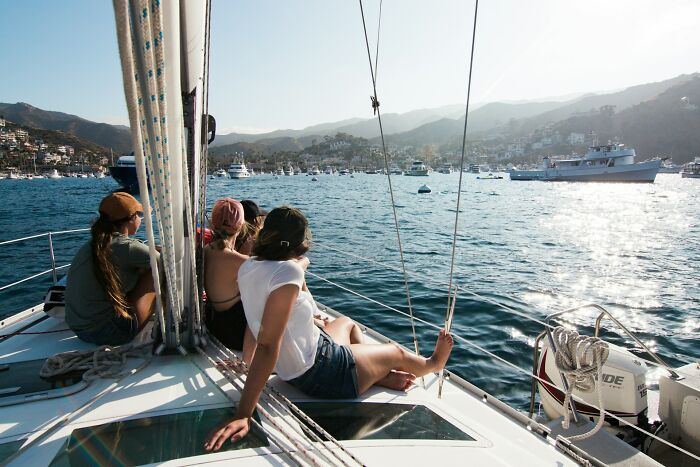 Four friends relaxing on a sailboat enjoying sunny weather, capturing candid wedding moments that turned out to be accurate.