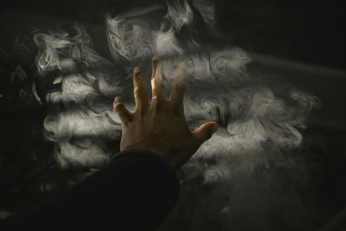 Hand reaching into swirling smoke, illustrating unusual normal practices in Europe that the US may find weird.