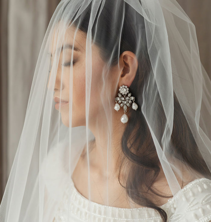 Teen bride with veil and pearl earrings, representing forced marriage and a plan for divorce.