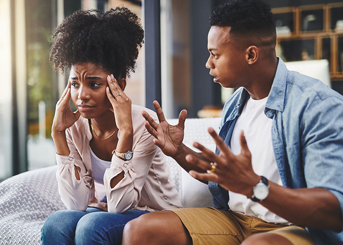 Young man discussing open relationship with upset younger coworker showing disinterest during a tense conversation.