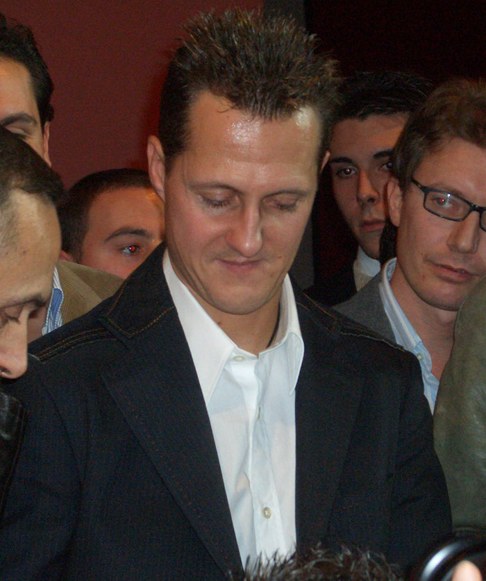 Michael Schumacher surrounded by fans and media during an event before his major F1 accident and health update.
