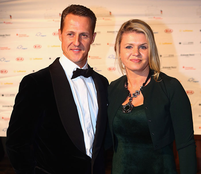 Michael Schumacher and woman posing at a formal event, relating to major health update about F1 legend's condition.