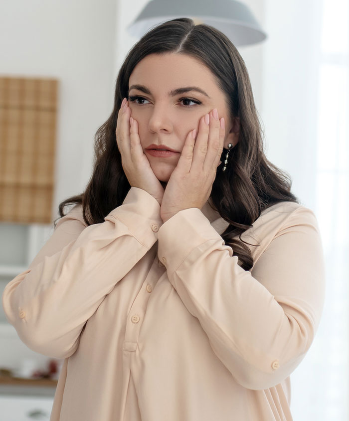 Upset mom storms off, holding her face in a kitchen, tense moment after mother-in-law tried to take over feeding