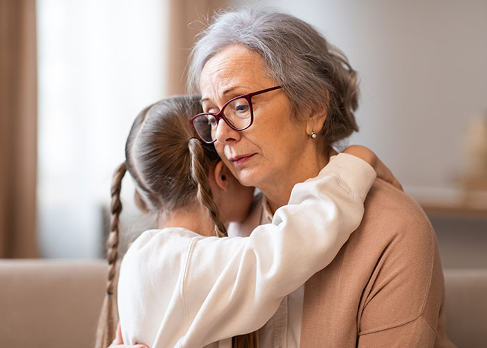 Military veteran consoling child while gently telling kids about parents passed away in a quiet home setting.
