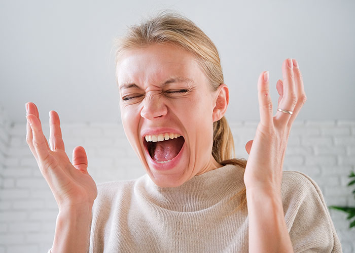 Woman expressing shock and frustration while reacting to mil telling kids their parents passed away at home.