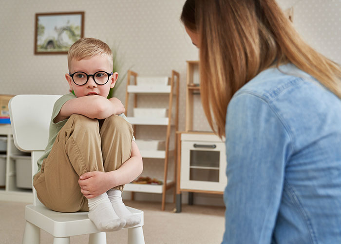 Military member telling kids about parents passed away in a calm room with thoughtful child and adult having conversation