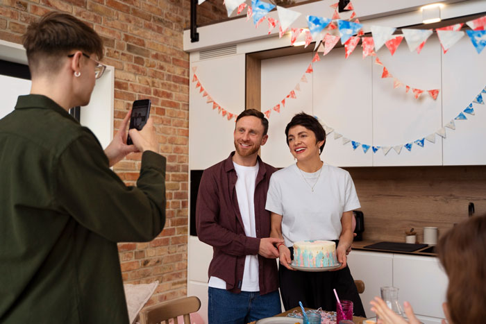 Sibling taking mom out for birthday dinner while brothers skip pitching in for the gift, celebrating with cake and smiles.