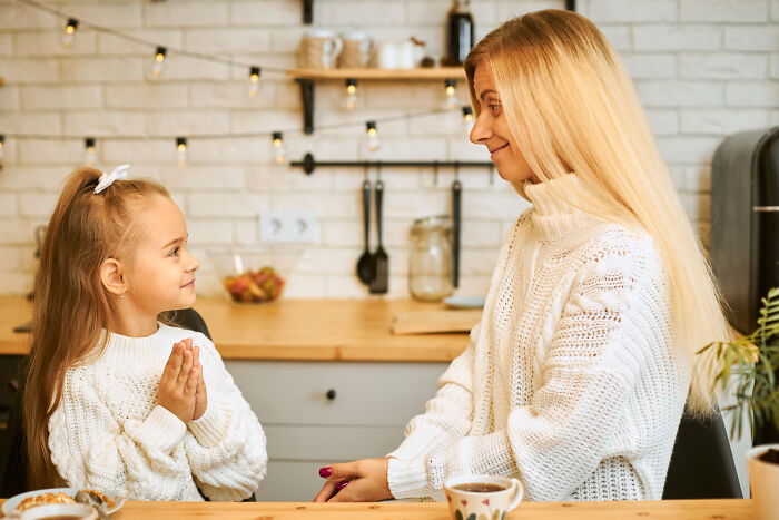 Guest mom rearranges food and gently corrects child during a b-day party, taking control of the house atmosphere.