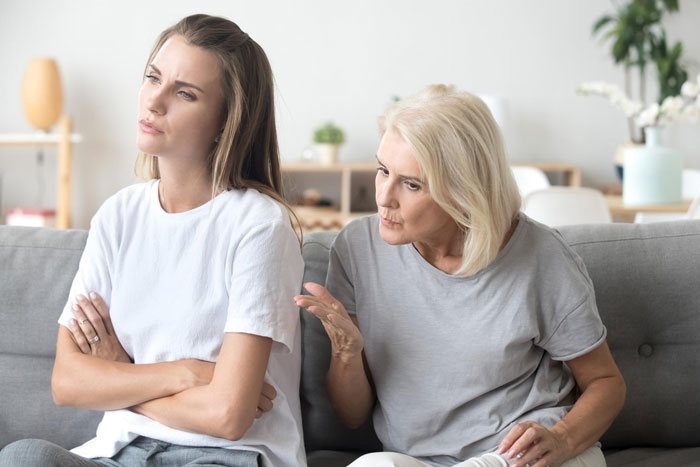 Mom and bride-to-be having a tense conversation about including sister&rsquo;s unruly kids at the wedding in a living room setting.