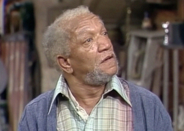 Elderly man with gray hair and beard wearing plaid shirt and cardigan looking up, symbolizing ironic ways people passed away.