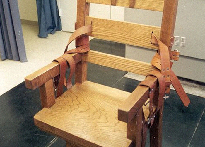 Wooden electric chair with leather straps, illustrating a tool related to ironic ways people passed away.