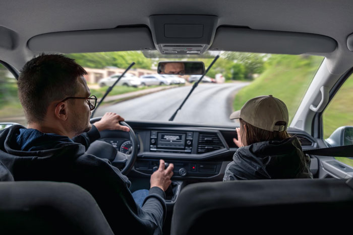 Father driving a car with a mother beside him during an airport trip drama on a rainy day. Father driving a car with a mother beside him during an airport trip drama on a rainy day.
