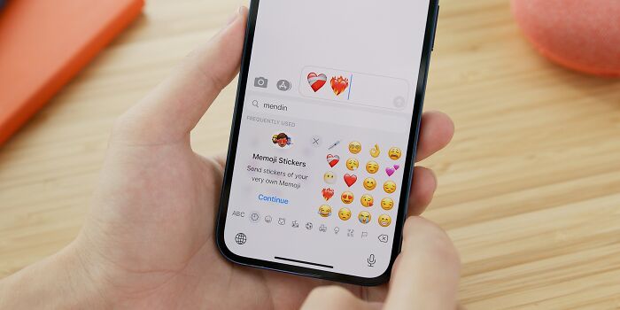 Person holding a phone showing accidental texts with emojis, illustrating the theme of panic from texting mistakes.