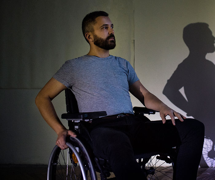 Man in wheelchair looking thoughtful, depicting situations with overwhelming feelings that make people need to leave.