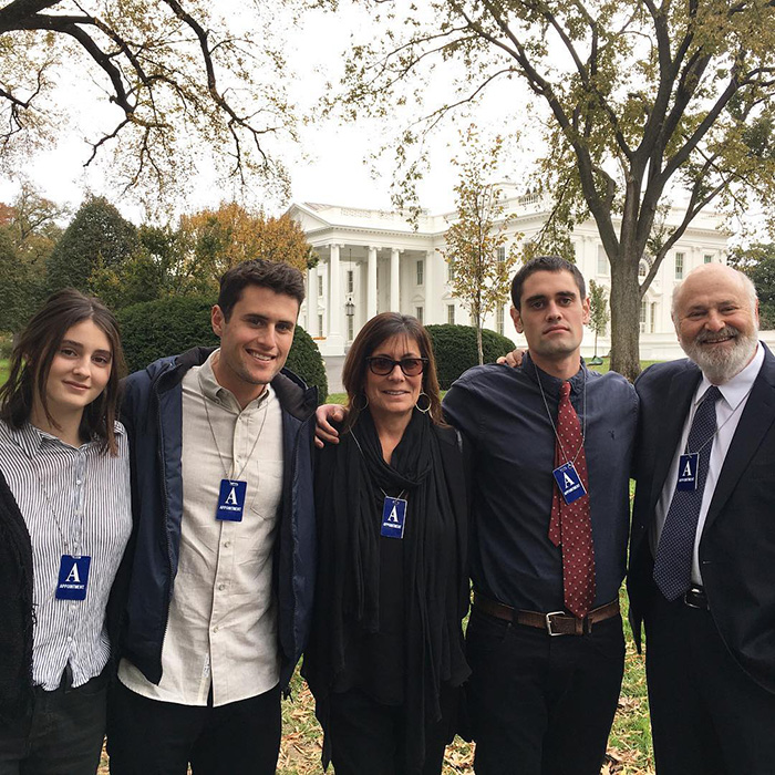 Nick Reiner&rsquo;s family standing together outside with visitor badges in front of the White House during autumn season.