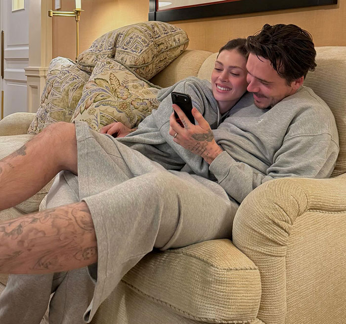 Nicola Peltz and partner relaxing on couch, showing tattoo that appears to be pointed message at Beckham family.