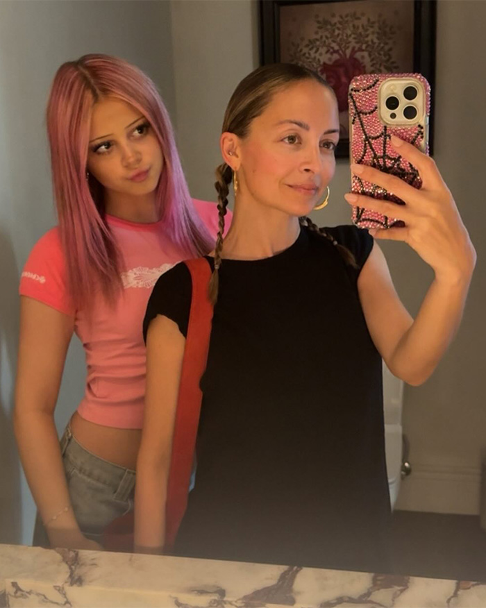 Nicole Richie taking a mirror selfie with her daughter, who has pink hair and wears a pink top.