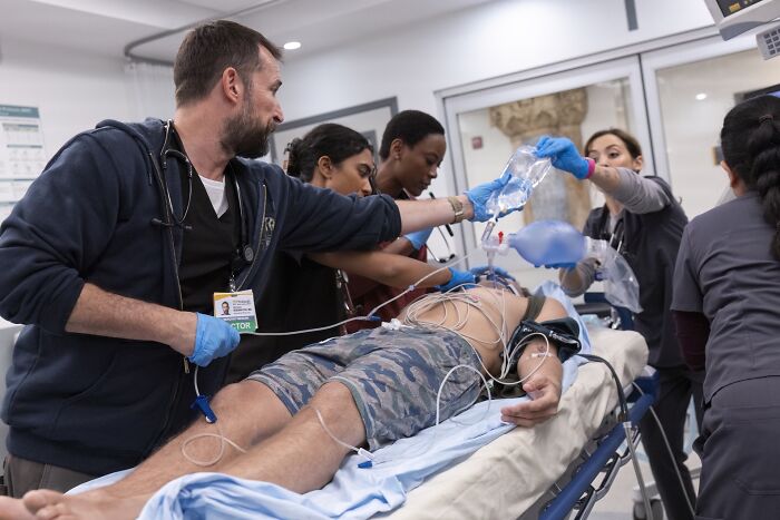 Medical team performing emergency care on patient in hospital, illustrating realistic medical cases with active monitoring and treatment.