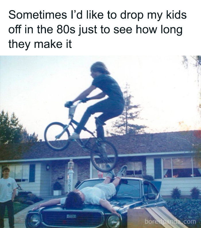 A nostalgic 80s scene showing a kid jumping a bike over a person lying on a vintage car in a suburban backyard.