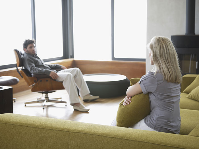 Man demands paternity test for 3-year-old son while woman suggests therapy in modern living room debate.