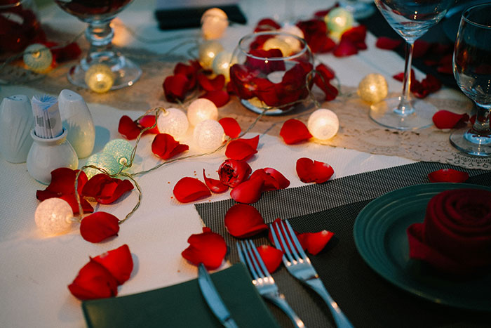 Romantic dinner table with rose petals and fairy lights, illustrating cooking and relationship themes for bald and divorced man story.