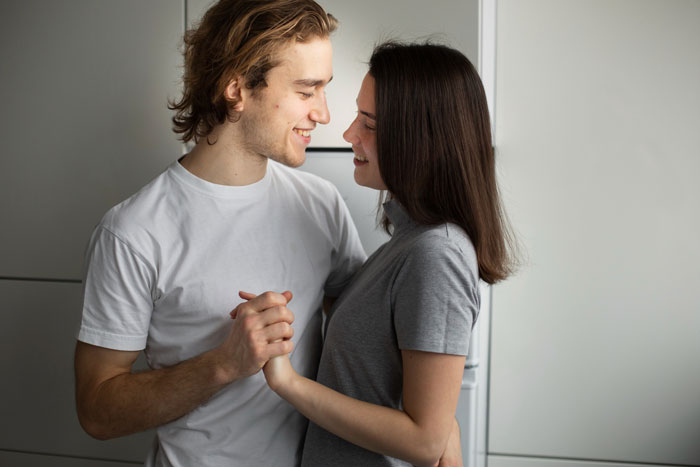 Young adult couple embracing and smiling, illustrating themes of parents disowning adult worker daughter and fiancé. Young adult couple embracing and smiling, illustrating themes of parents disowning adult worker daughter and fiancé.