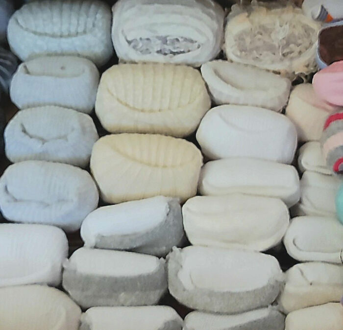 Stacked neatly folded socks in various light colors demonstrating an organized real-life cheat code for easy access.