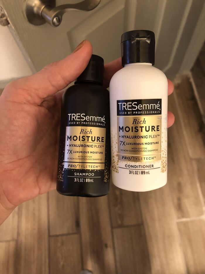 Hand holding TRESemmé Rich Moisture shampoo and conditioner bottles, popular real-life cheat codes for hair care.
