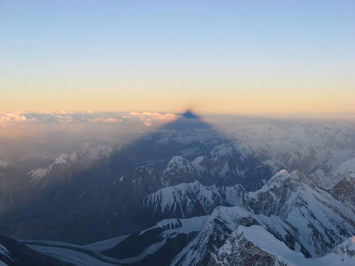Snow-capped mountain peaks at sunrise with a shadow cast, a powerful photo representing countries that hit hard.