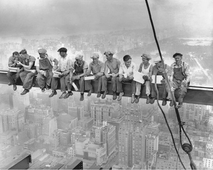 Construction workers sitting on a steel beam high above a city, a powerful photo from their country that hits hard.