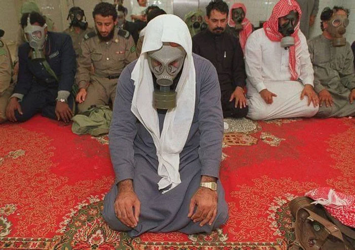 Men wearing traditional clothes and gas masks sitting on a carpet in a photo shared from their country that hits hard.