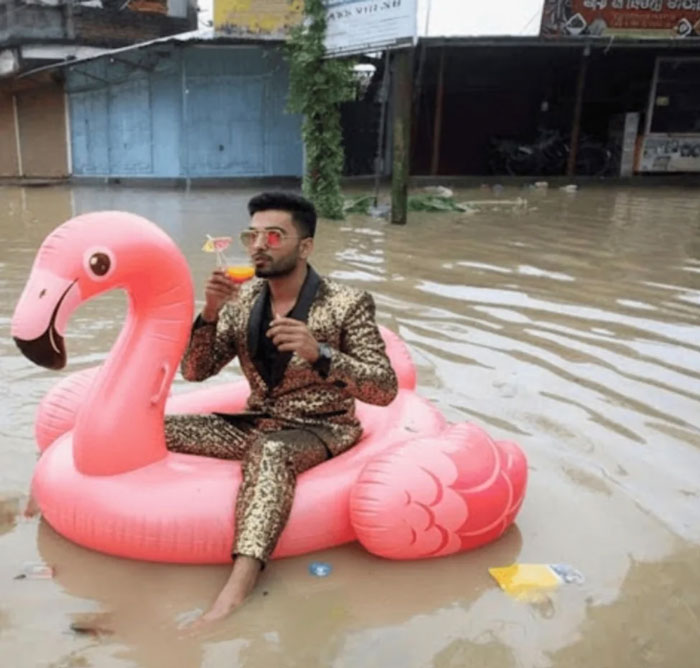 Man in a gold suit sits on pink flamingo float in floodwaters, illustrating striking photos from countries that hit hard.