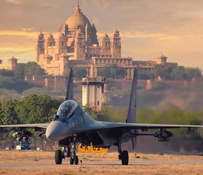 Military jet on runway with historic palace in background, a powerful photo from countries that hit hard emotions.