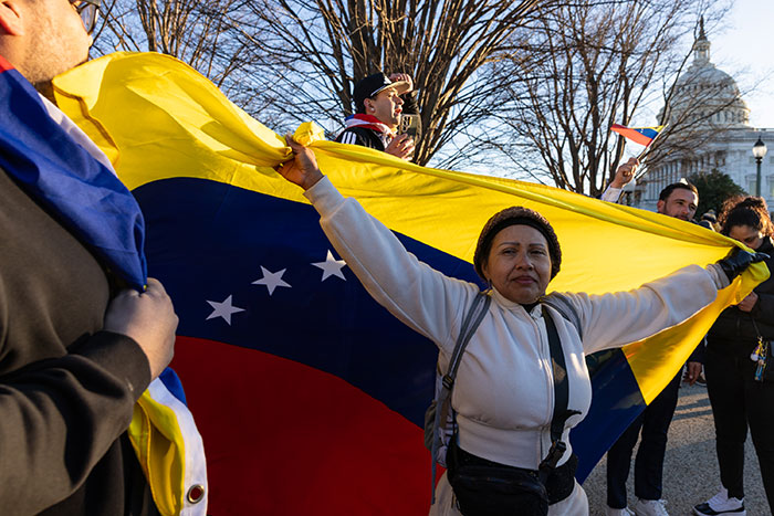 Protester holding Venezuelan flag with US Capitol in background amid Nobel Committee peace prize discussion.
