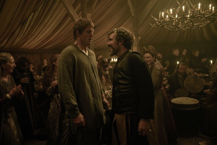 Peter Claffey and another character in medieval attire at a lively banquet, highlighting Ser Duncan The Tall's height comparison.