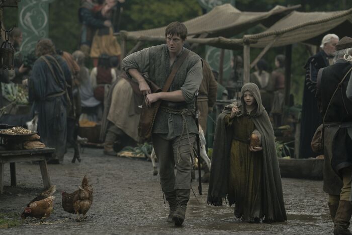 Medieval market scene with two characters walking, featuring a Knight of the Seven Kingdoms setting and villagers around. Medieval market scene with two characters walking, featuring a Knight of the Seven Kingdoms setting and villagers around.