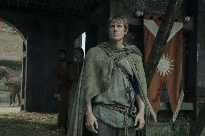 Young man dressed in medieval clothing standing in a barn, representing A Knight Of The Seven Kingdoms streaming success. Young man dressed in medieval clothing standing in a barn, representing A Knight Of The Seven Kingdoms streaming success.