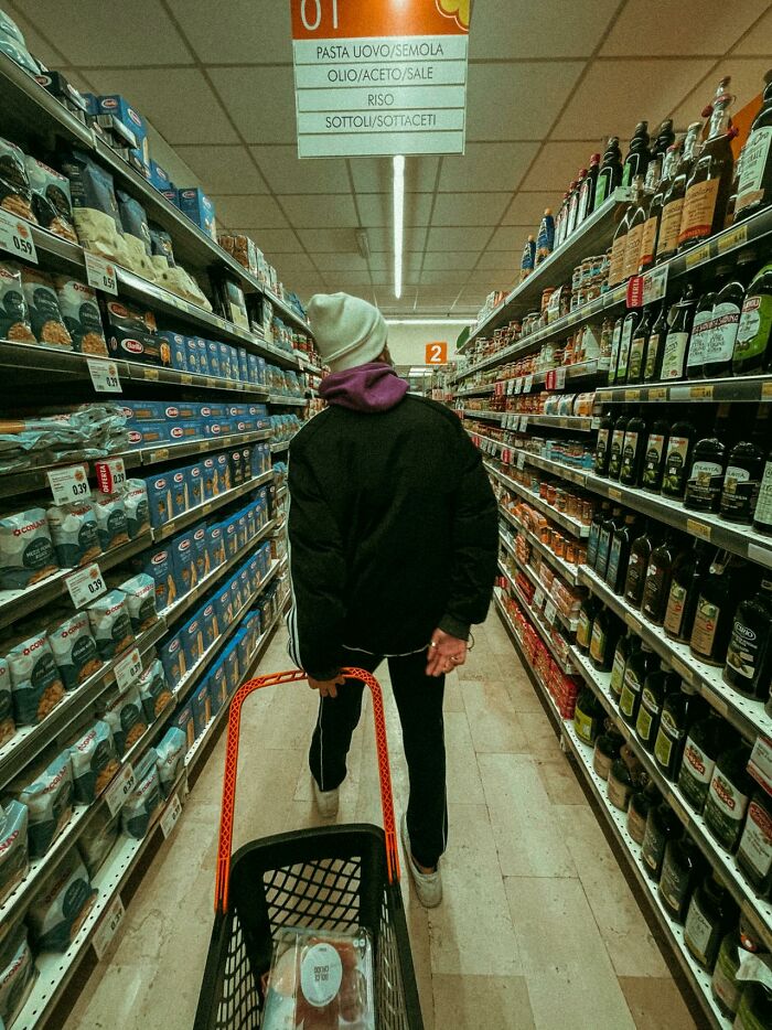 Person pushing a shopping cart in a grocery aisle, illustrating things that shocked people after they got out of prison.