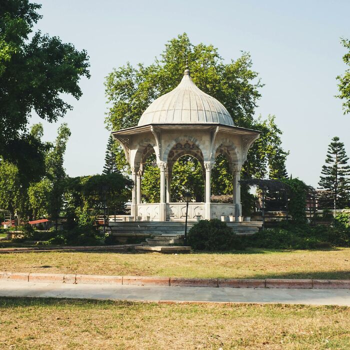 Historic gazebo in a peaceful park surrounded by trees, symbolizing uplifting stories of progress and hope in America.