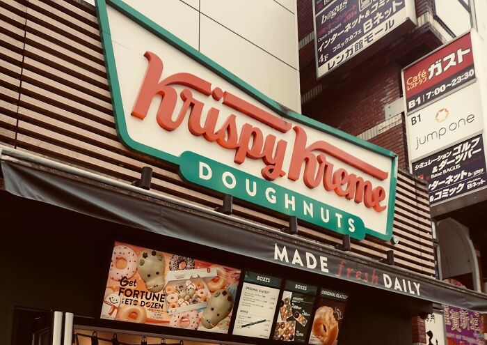 Krispy Kreme doughnuts storefront with signs, captured in a satisfying moment from weird and iconic situations.